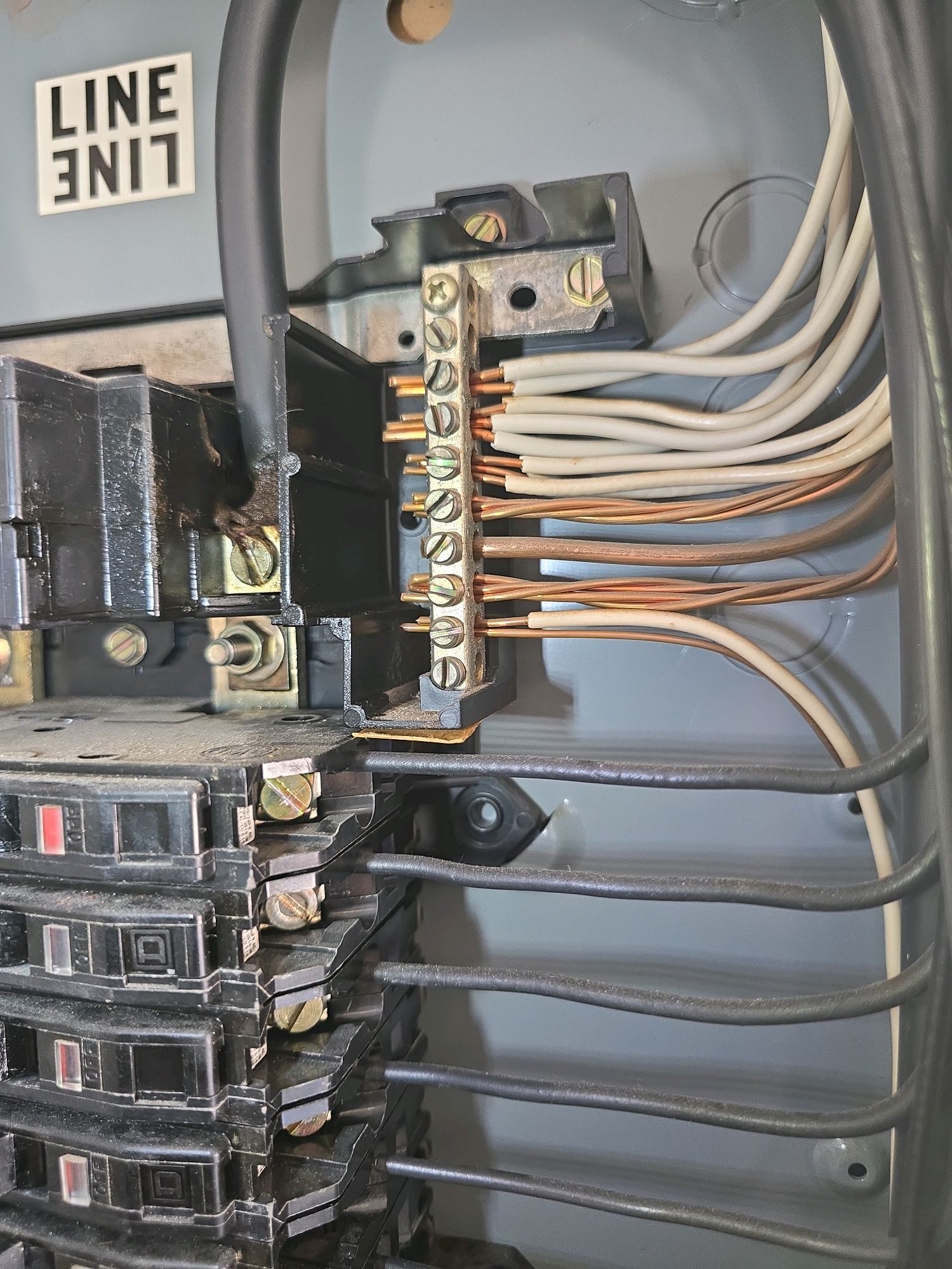 Interior of an electrical panel showing the neutral bus bar inspected for double-tapped conductors