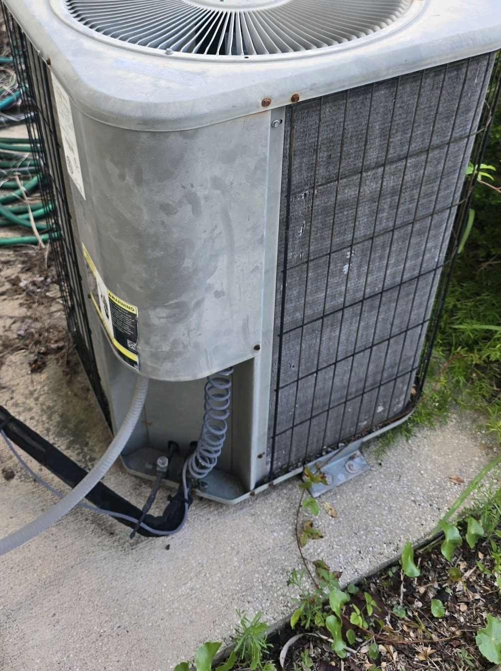 Outdoor HVAC condensing unit checked during an inspection